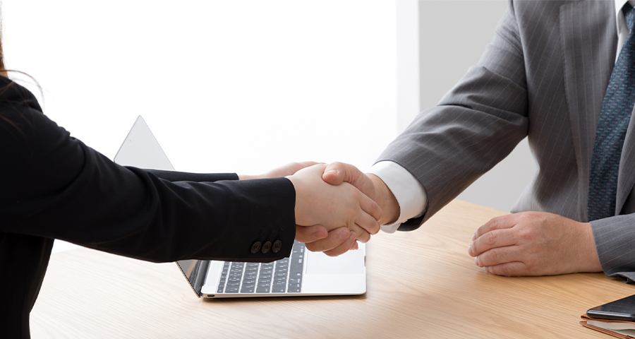 女性と男性が握手をしている写真